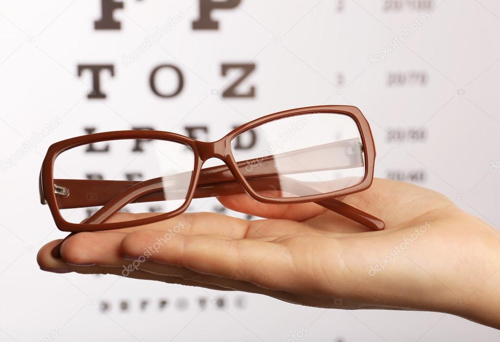Eye glasses on eyesight test chart background
