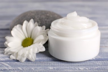 Spa taş ve ahşap arka plan üzerinde papatya ile kozmetik krem