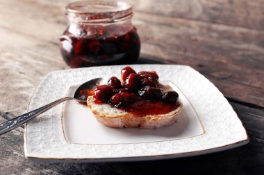 Ahşap arka plan üzerinde plaka üzerinde reçelli taze ekmek