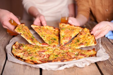Dilim pizza alarak arkadaşlar eller