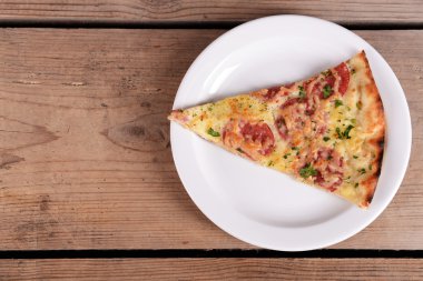 Lezzetli dilim pizza ahşap masa üzerinde plaka üzerinde