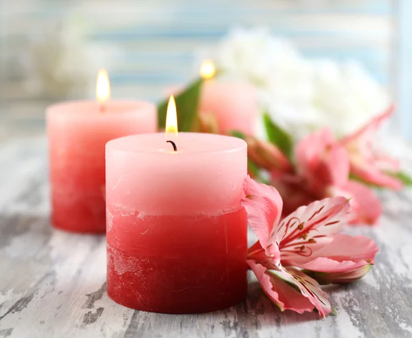 Schöne Kerzen mit Blumen auf Holzgrund — Stockfoto