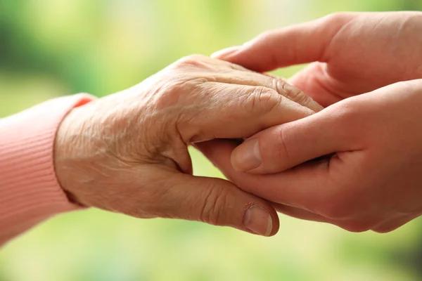 Oud en jong bedrijf handen op lichte achtergrond, close-up — Stockfoto