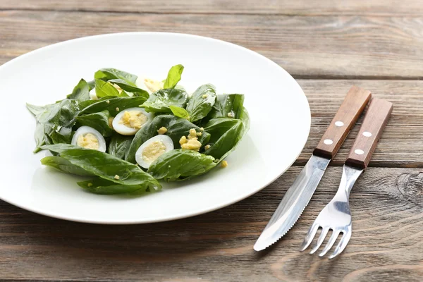 Salad with quail egg and basil in plate on rustic wooden table background — Stock Photo, Image