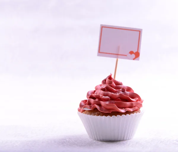 Heerlijke cupcake met inscriptie op tafel op beige achtergrond — Stockfoto