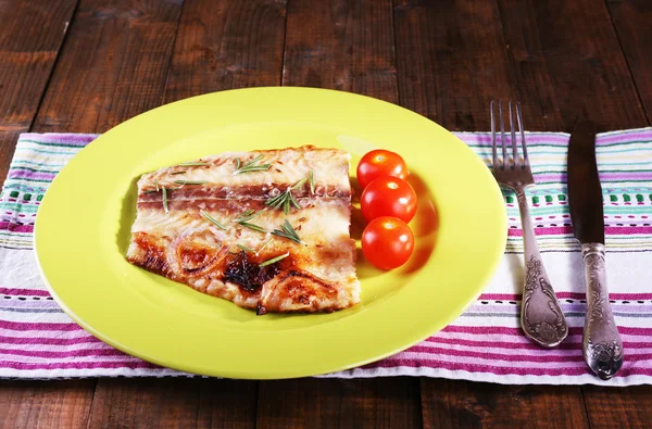 Schotel van Pangasius filet met rozemarijn en cherry tomaten in plaat op houten tafel achtergrond — Stockfoto