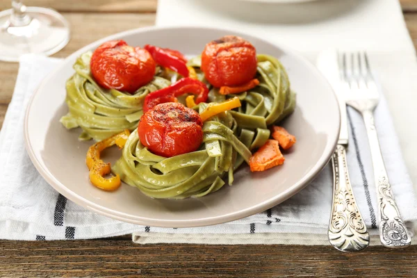 Leckere Pasta mit Paprika, Karotten und Tomaten auf Holztischhintergrund — Stockfoto