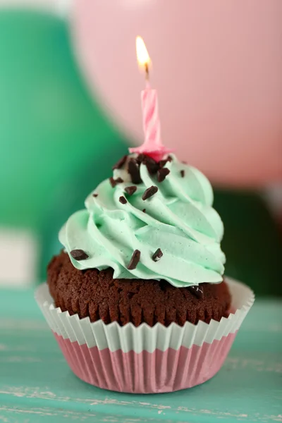 Delicioso cupcake de cumpleaños en la mesa sobre fondo brillante — Foto de Stock