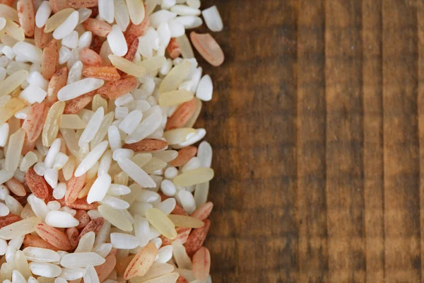 Verschiedene Reissorten auf hölzernem Hintergrund — Stockfoto