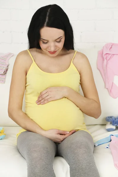 Giovane donna incinta rilassante sul divano, primo piano — Foto Stock