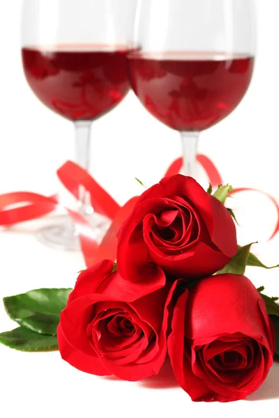 Composition avec vin rouge en verres, roses rouges, ruban et coeurs décoratifs sur fond clair — Photo