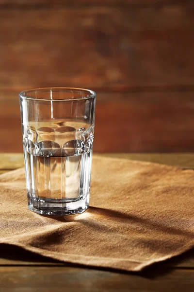 Стакан воды на столе на деревянном фоне — стоковое фото