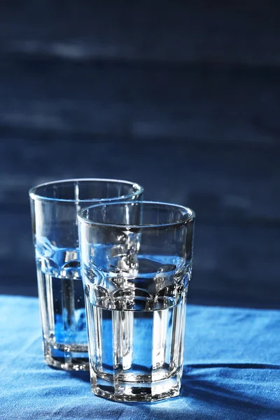 Twee glazen water op tafel op houten achtergrond — Stockfoto