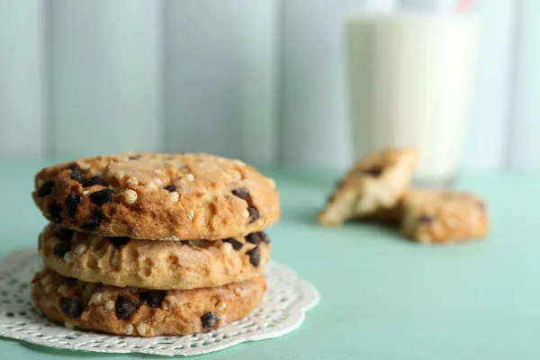 Sabrosas galletas y vaso de leche sobre fondo de madera de color — Foto de Stock