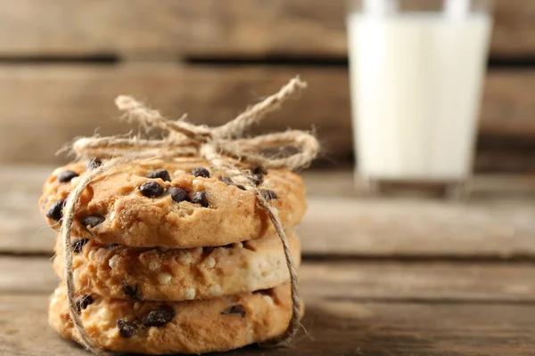 Cookie-uri gustoase și pahar de lapte pe fundal rustic din lemn — Fotografie, imagine de stoc