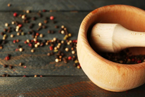 Mistura de pimentos em argamassa sobre fundo de madeira — Fotografia de Stock