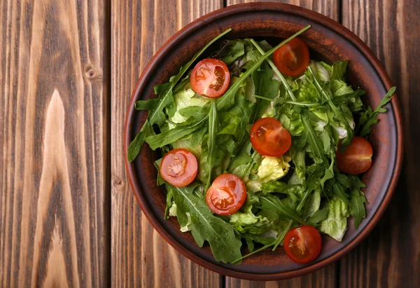 Ensalada con rúcula y tomates cherry sobre mesa de madera — Foto de Stock