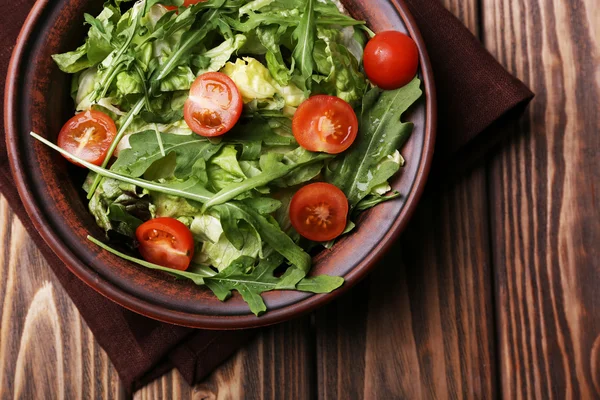 Salad with arugula and cherry tomatoes on wooden table — Stock Photo, Image