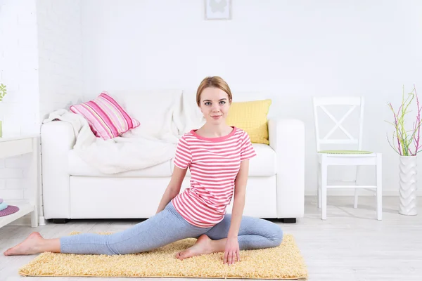 Mujer joven haciendo yoga en casa — Foto de Stock