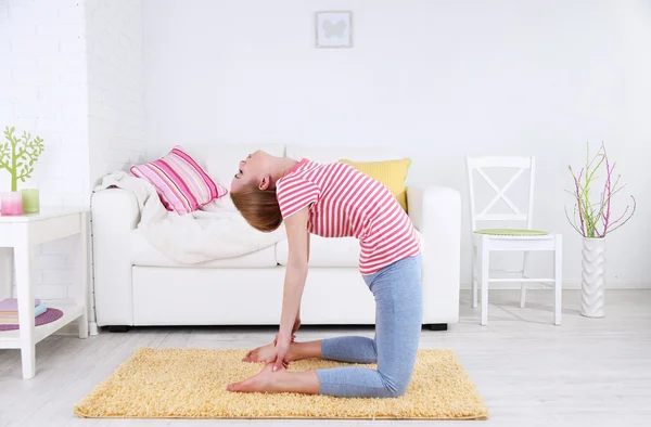 Mujer joven haciendo yoga en casa — Foto de Stock
