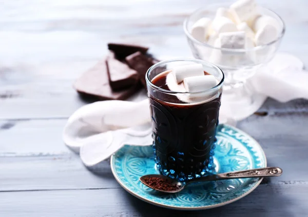 Heiße Schokolade mit Marshmallows im Glas, auf farbigem Holzgrund — Stockfoto