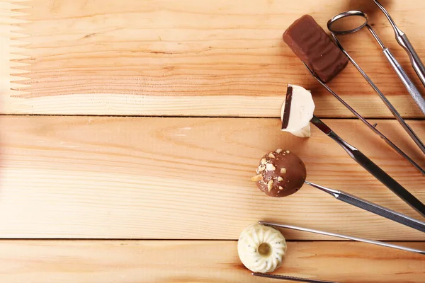 Fogorvos eszközöket, édesség, fából készült háttér — Stock Fotó