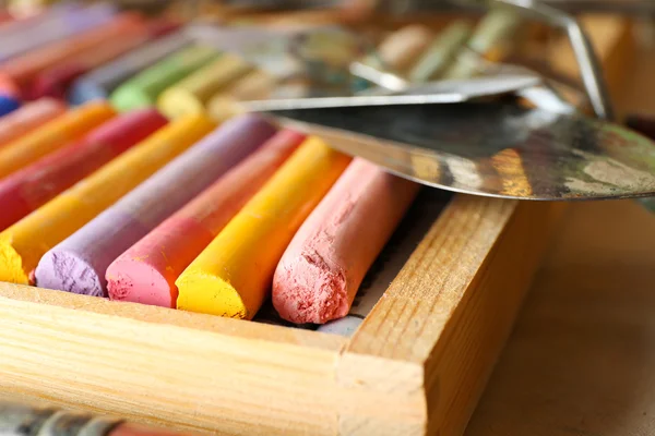 Pastéis de giz coloridos em caixa com facas de paleta de perto — Fotografia de Stock