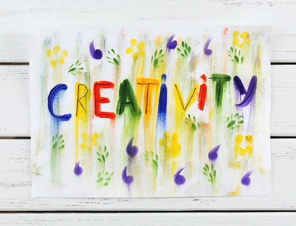 Wort Kreativität auf Papier auf Holzgrund geschrieben — Stockfoto