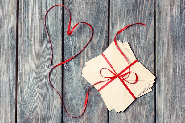 Cartas de amor con cinta roja sobre fondo de madera — Foto de Stock