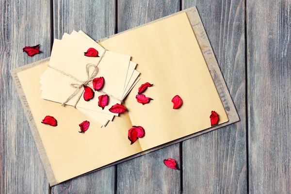 Letras de amor y pétalos de rosa sobre fondo de madera — Foto de Stock