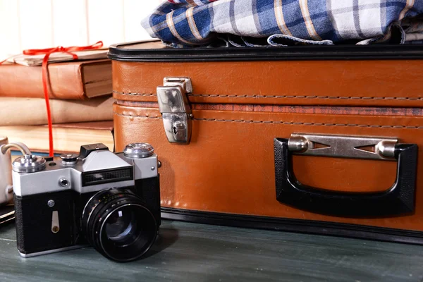 Vintage-Koffer mit Kleidung und Büchern auf Holzgrund — Stockfoto