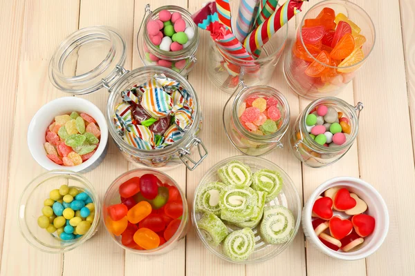 Sweetness in different containers on wooden background — Stock Photo, Image