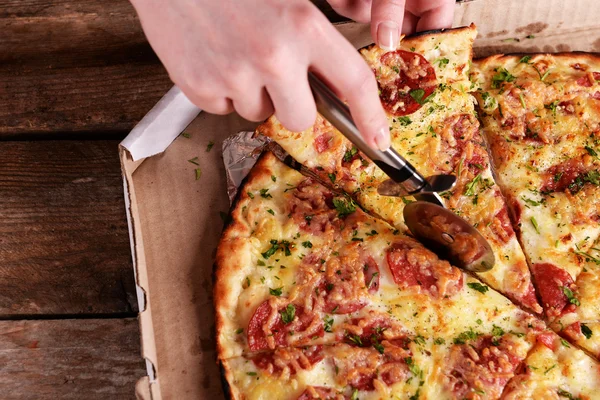 Girl cut pizza on table close up — Stock Photo, Image