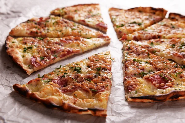 Smakelijke pizza op papier close-up — Stockfoto