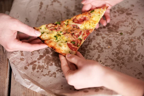 Friends hands taking slice of pizza — Stock Photo, Image