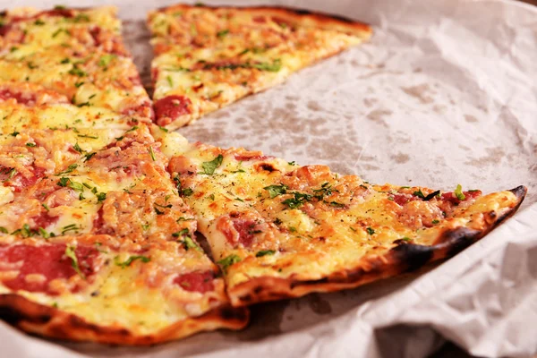 Gustosa pizza su carta da vicino — Foto Stock