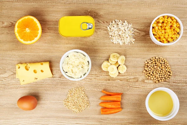Различные пищевые продукты, содержащие витамины на деревянном фоне — стоковое фото