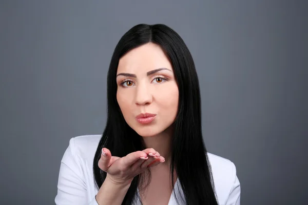 Portrait of young woman on grey background — Stock Photo, Image