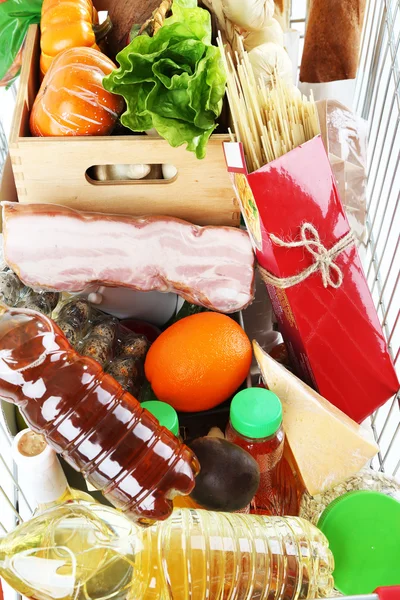 Shopping cart full with various groceries, close-up — Stock Photo, Image