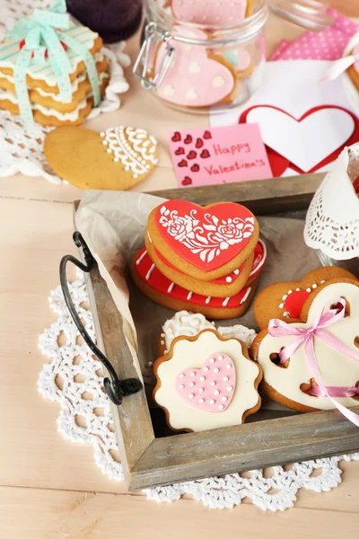 Biscotti a forma di cuore per San Valentino su vassoio, su sfondo di legno a colori — Foto Stock