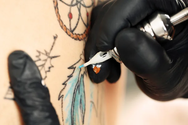 Tattooer showing process of making tattoo, close up — Stock Photo, Image