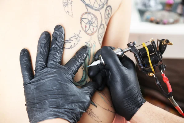 Tattooer showing process of making tattoo, close up — Stock Photo, Image