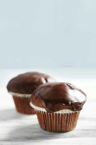 Leckere hausgemachte Schokoladenmuffins auf Holztisch, auf hellem Hintergrund — Stockfoto