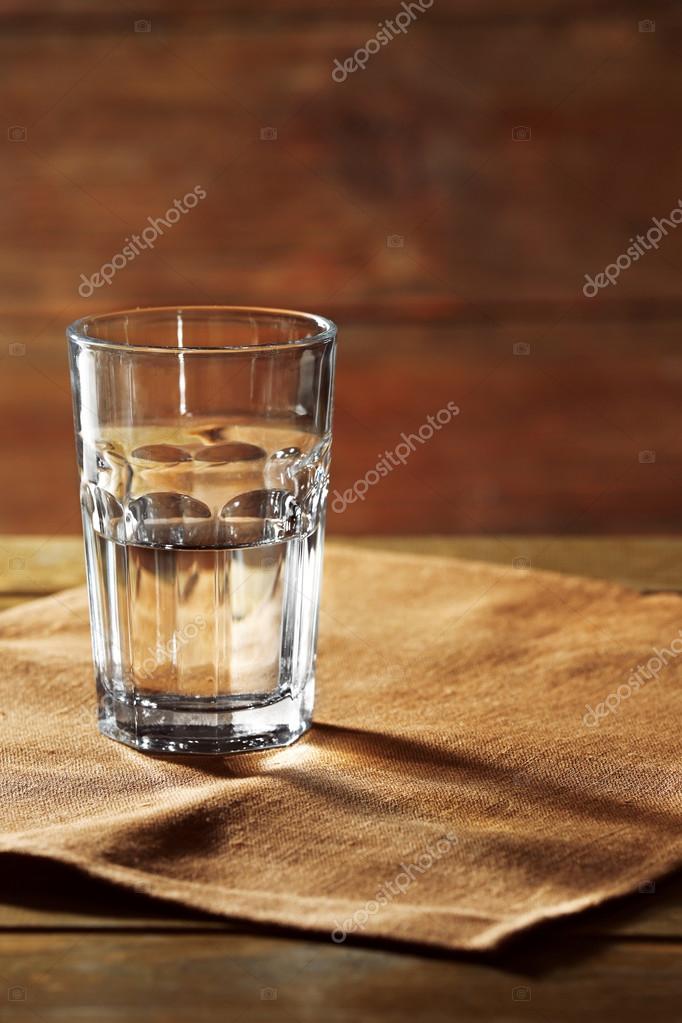 Glass of water on table on wooden background Stock Photo by ©belchonock