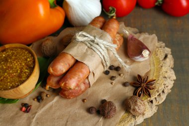 İnce sosis, hardal kase ve ahşap zemin üzerine baharat bileşimi