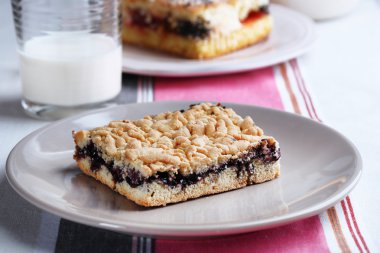 Reçel ve çizgili masa örtüsü arka plan üzerinde süt ile ev yapımı börek