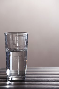 Temiz mineral su üzerinde ahşap yüzey ve ışık arka plan plakalar