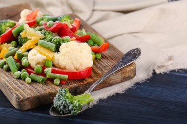 Peçeteye ahşap masa arka plan üzerinde kesme tahtası üzerinde Dondurulmuş sebzeler