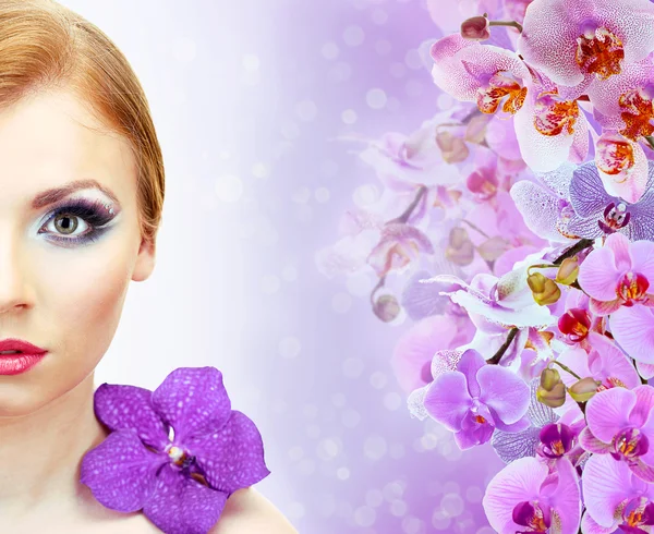 Hermosa mujer joven con flor de orquídea sobre fondo de color con flores de orquídea — Foto de Stock