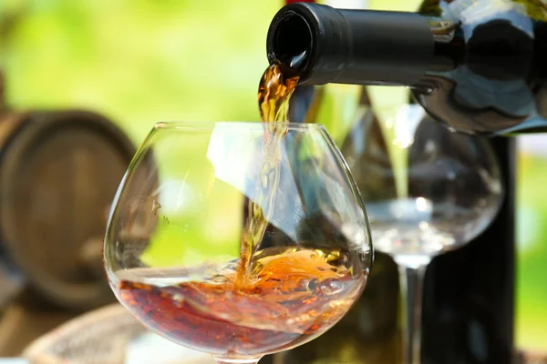 Červené víno nalévání do sklenice na víno, detailní záběr — Stock fotografie